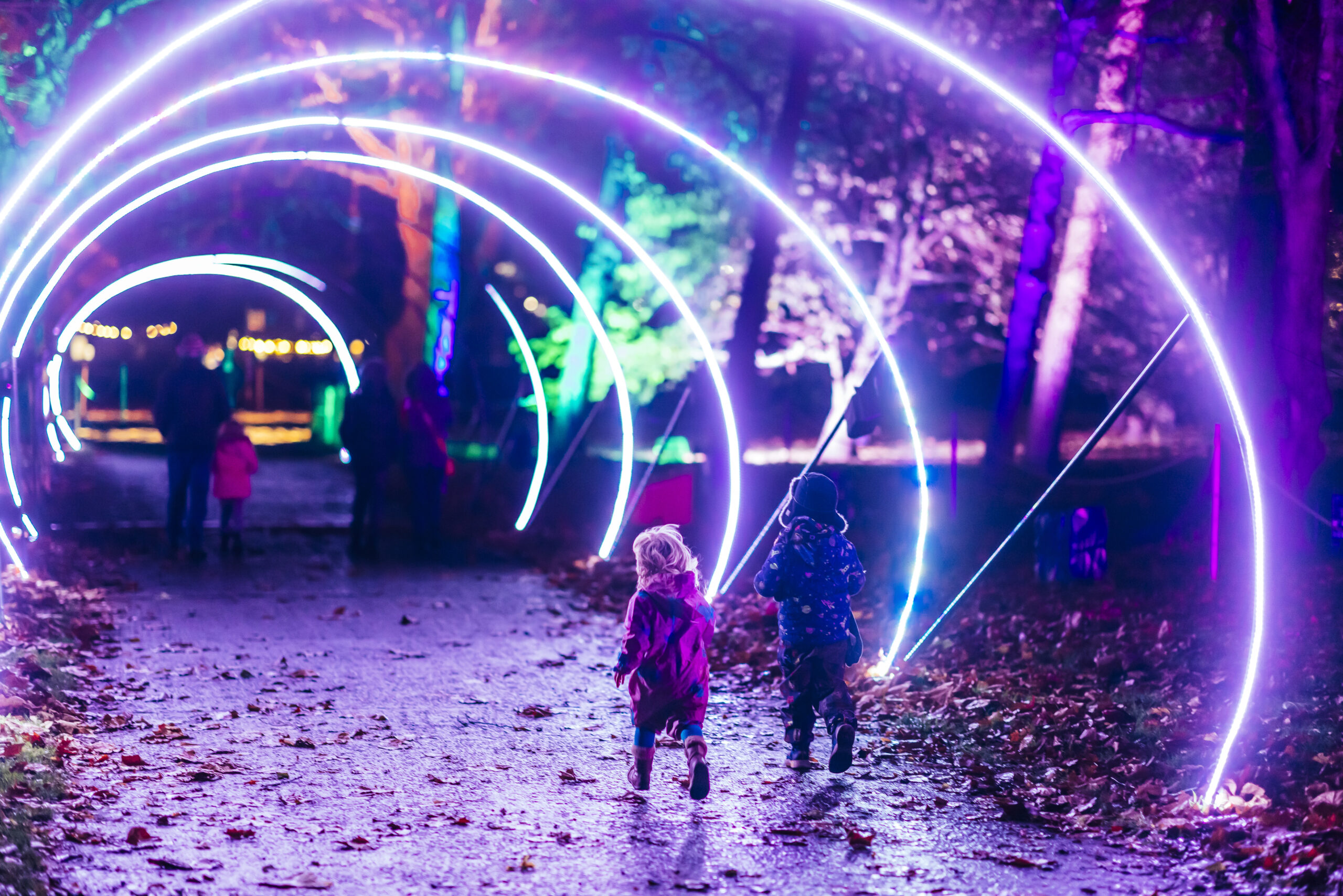 Children running through the Christmas Twist illumination.